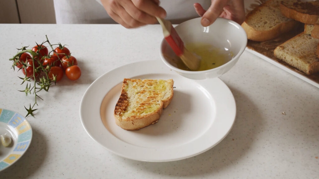 Brush the bread with olive oil.